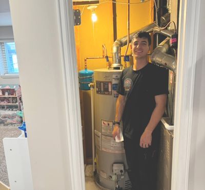 Apprentice plumber from Mr Perfect Plumbing smiling after a successful water heater installation